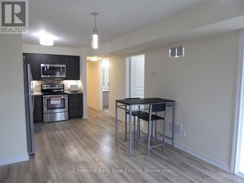 A kitchen with a black counter top and stainless steel appliances.