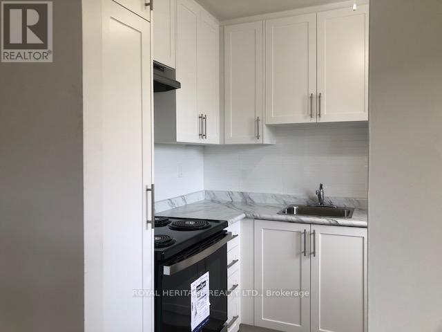 A kitchen with white cabinets and a black stove top oven.