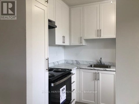 A kitchen with white cabinets and a black stove top oven.