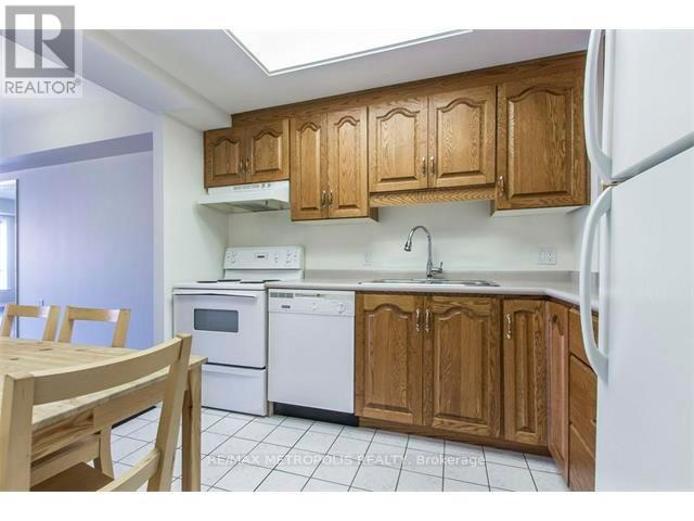 A kitchen with wooden cabinets and white appliances.