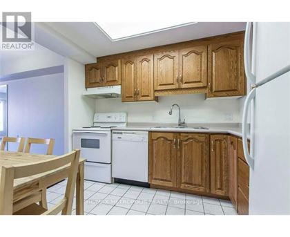 A kitchen with wooden cabinets and white appliances.