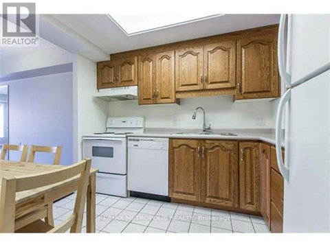 A kitchen with wooden cabinets and white appliances.