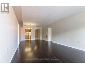 A spacious room with wooden floors and white walls, with a sign that reads "RE/MAX METROPOLITIC REALTY, Brokerage".