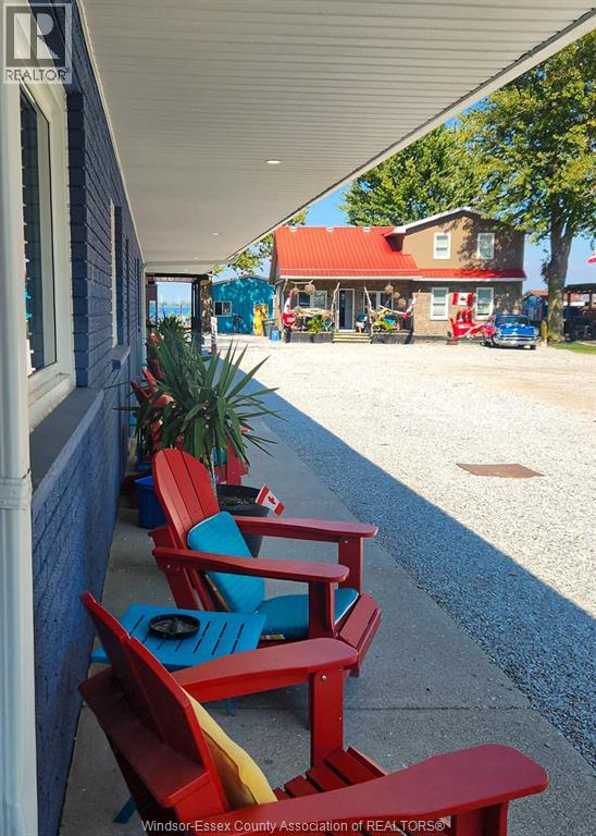 A row of red and blue chairs are lined up on a concrete walkway.