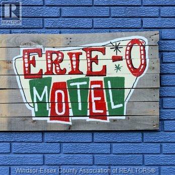 A wooden sign with the words "ERIE-O MOTEL" painted on it.