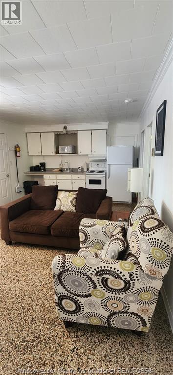 A living room with a brown couch and a patterned ottoman.