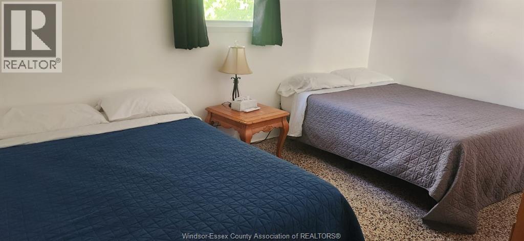 A bedroom with a blue bedspread and a bed with white pillows.