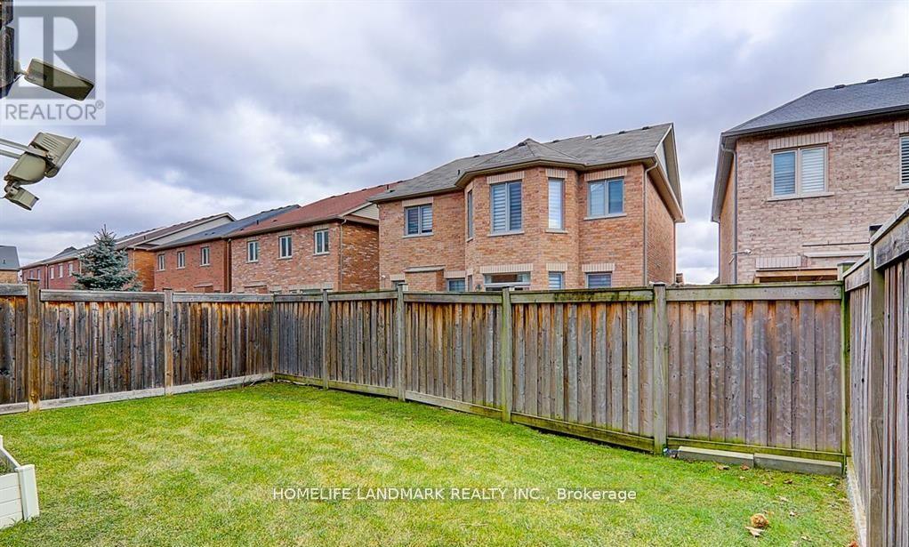 A backyard with a wooden fence and grass.