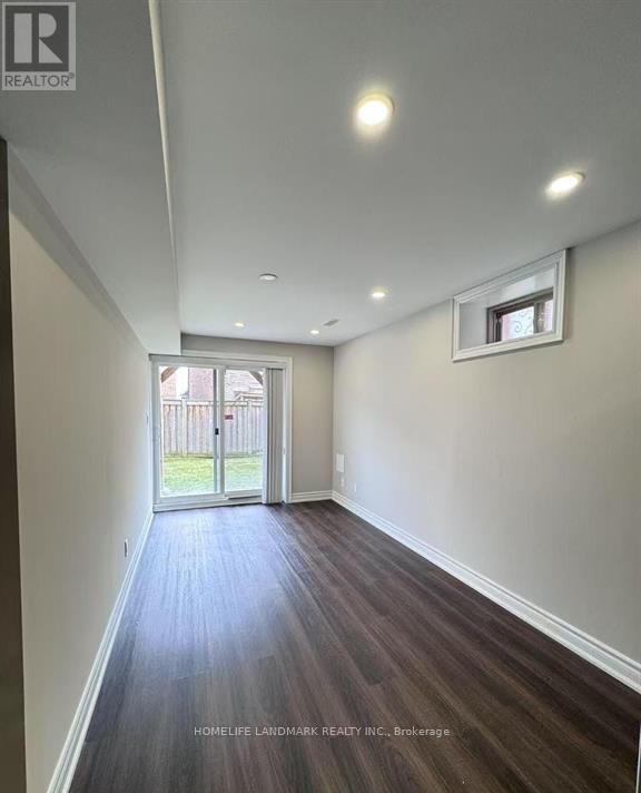 A hallway with wood flooring and white walls.
