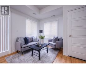 A living room with a grey couch, a black coffee table, and a grey armchair.