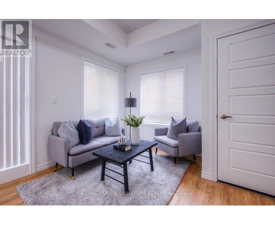 A living room with a grey couch, a black coffee table, and a grey armchair.