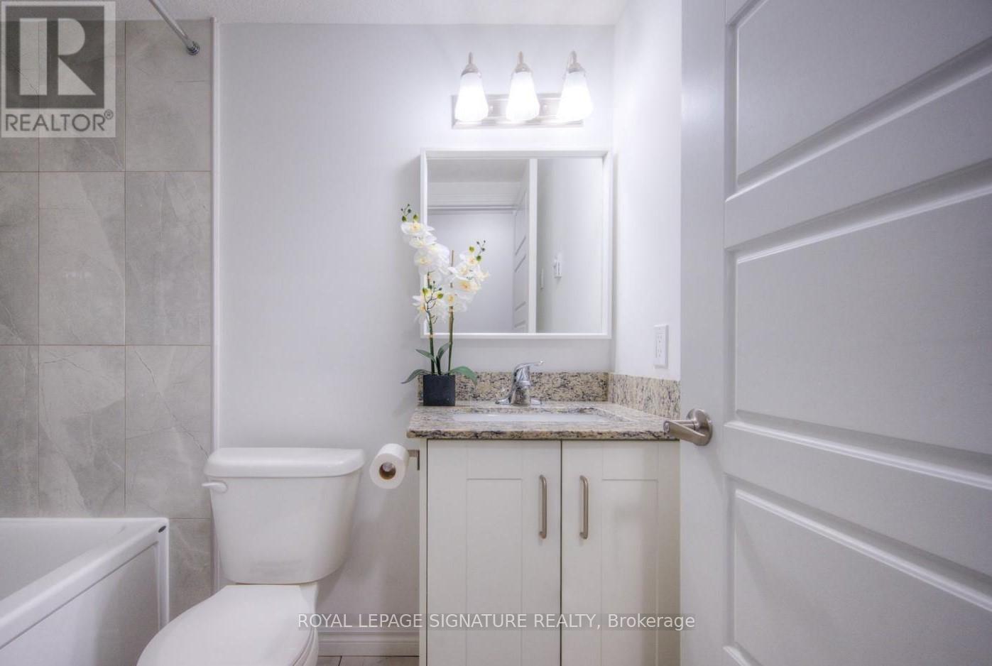 A white bathroom with a toilet, sink, and bathtub.