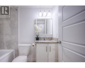 A white bathroom with a toilet, sink, and bathtub.