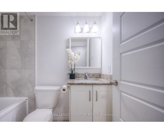 A white bathroom with a toilet, sink, and bathtub.