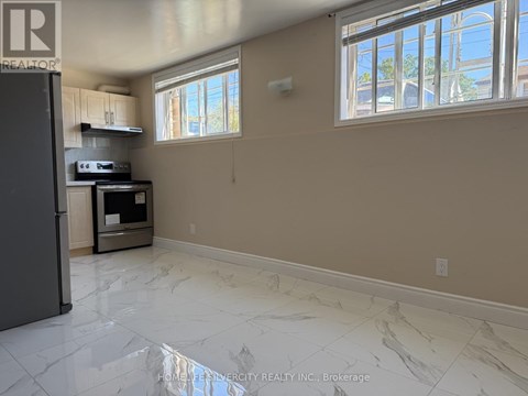 A kitchen with a refrigerator, oven, and microwave.
