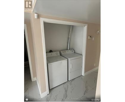 A small laundry room with a washer and dryer.