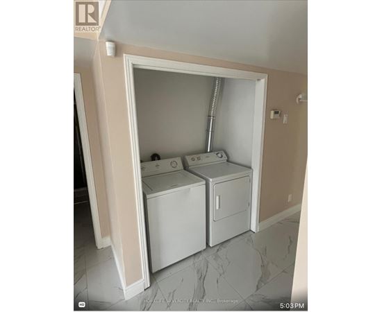 A small laundry room with a washer and dryer.