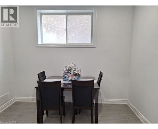 A dining room with a table and chairs.