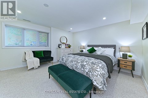 A bedroom with a large bed and a green bench.