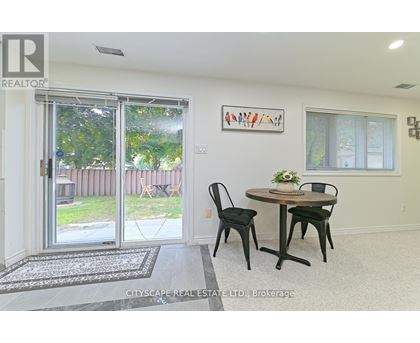 A dining room with a table and chairs and a painting on the wall.