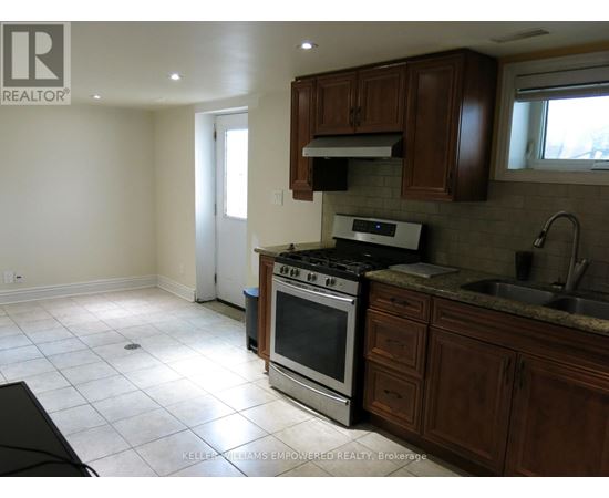 A kitchen with a stove top oven and a sink.