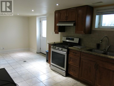A kitchen with a stove top oven and a sink.