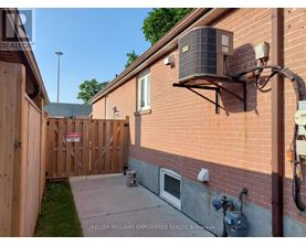 A red brick house with a wooden fence and a sign that says "No Trespassing".
