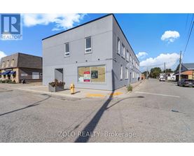 A grey building with a sign that says ZOLO REALTY Brokerage.
