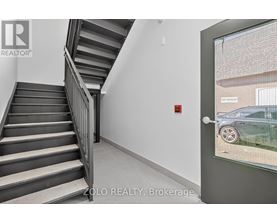 A staircase in a building with a glass door leading outside.
