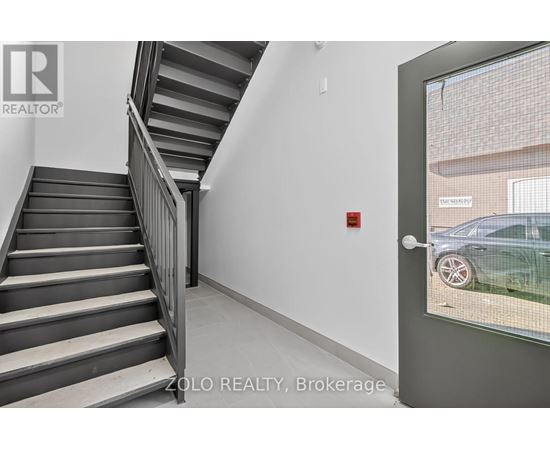 A staircase in a building with a glass door leading outside.