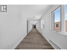 A long, empty hallway with a window on the right side.