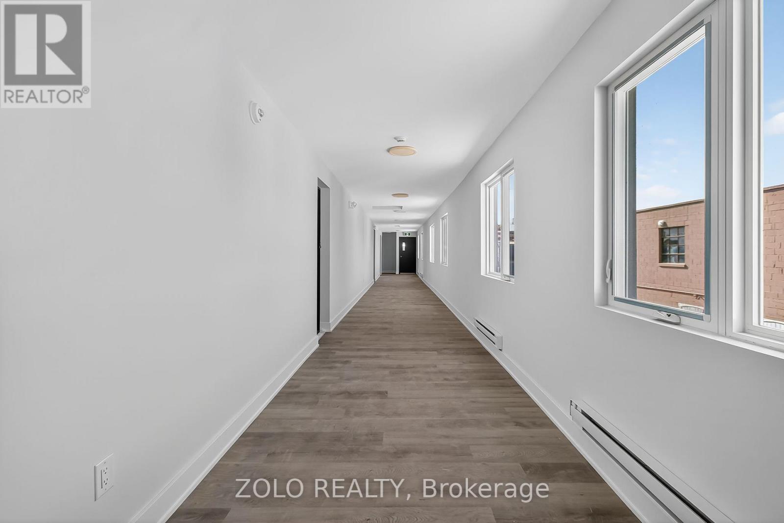 A long, empty hallway with a window on the right side.