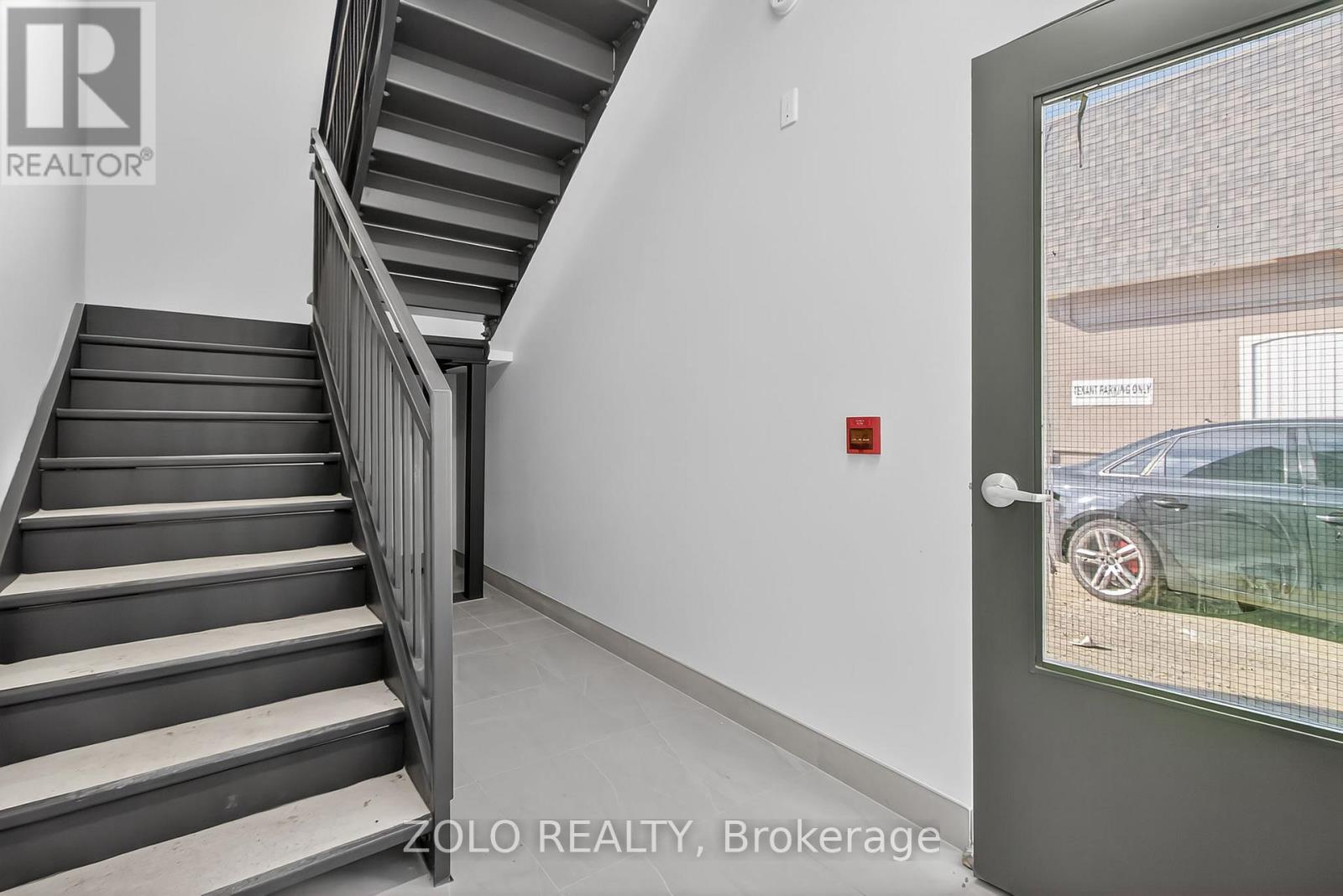 A staircase in a building with a glass door leading outside.
