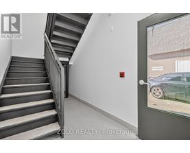 A staircase in a building with a glass door leading outside.