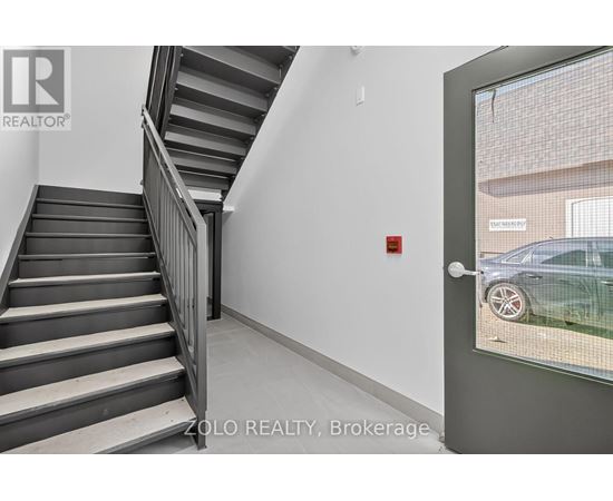 A staircase in a building with a glass door leading outside.