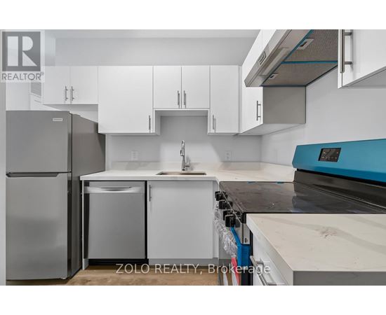 A kitchen with white cabinets and a blue counter.