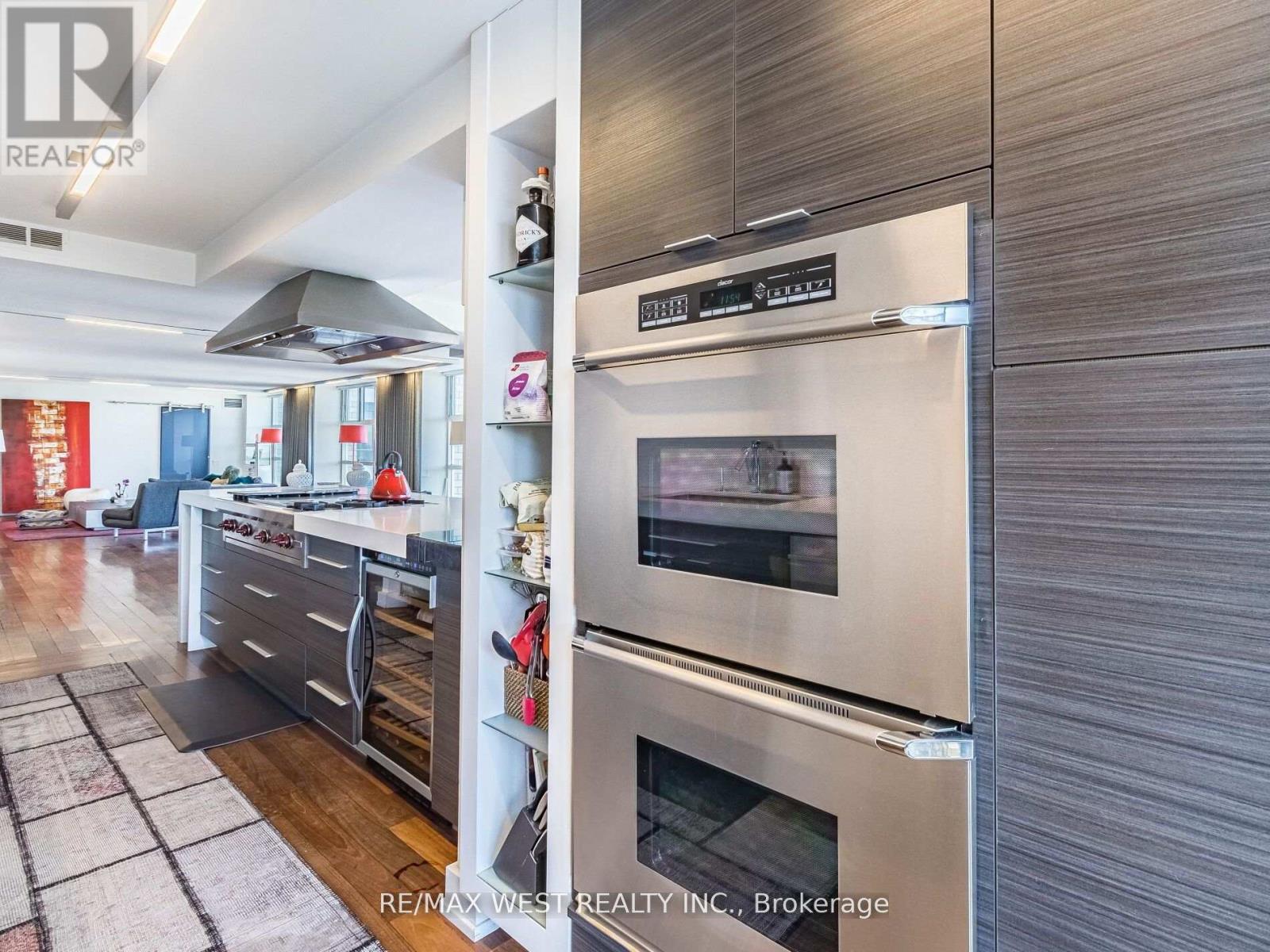 A modern kitchen with a stainless steel refrigerator and oven.
