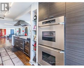 A modern kitchen with a stainless steel refrigerator and oven.