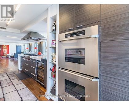 A modern kitchen with a stainless steel refrigerator and oven.