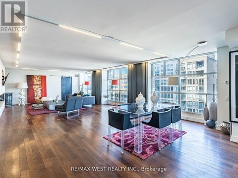 A spacious living room with a dining table and chairs.
