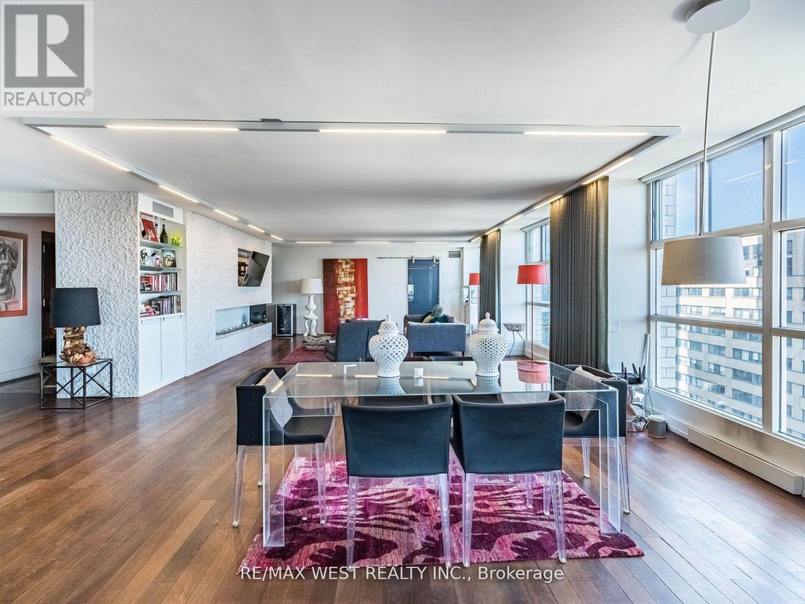 A modern dining room with a glass table and chairs.