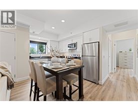 A modern kitchen with a dining table set for two.