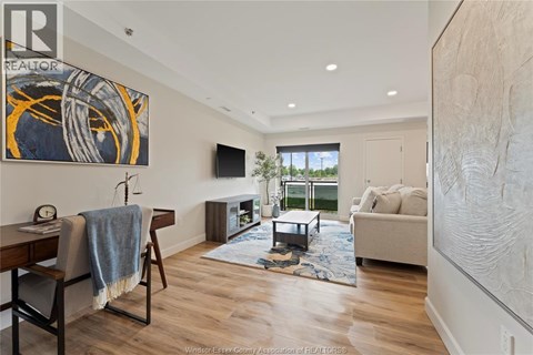 A living room with a couch, chair, and a painting on the wall.
