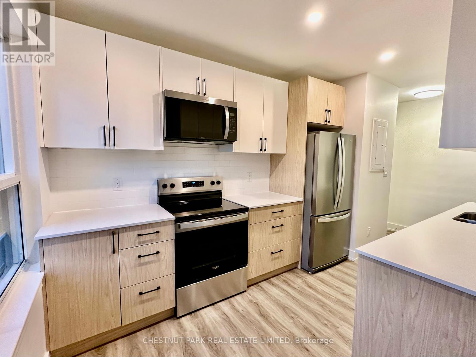 A kitchen with white cabinets and a microwave above the stove.