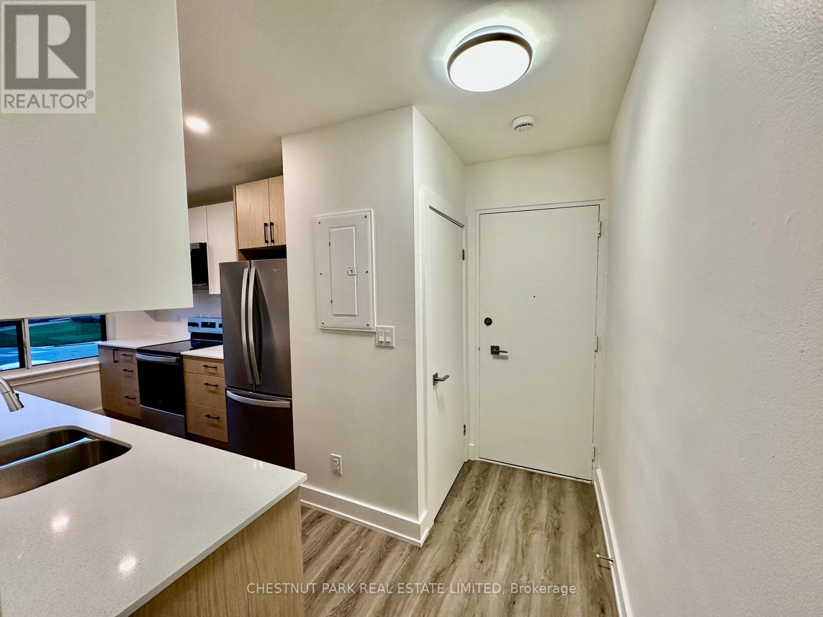A kitchen with white walls and a wooden floor.