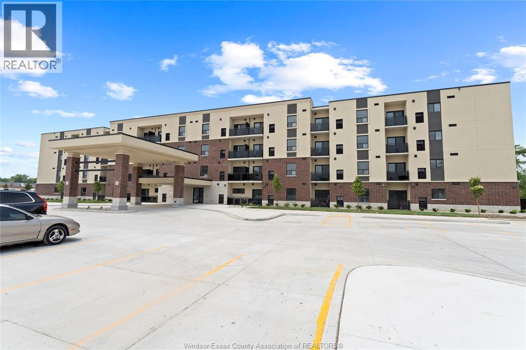 A large apartment complex with a parking lot in front.