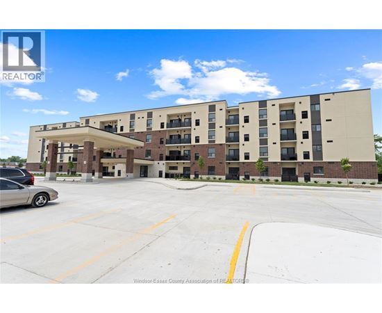 A large apartment complex with a parking lot in front.