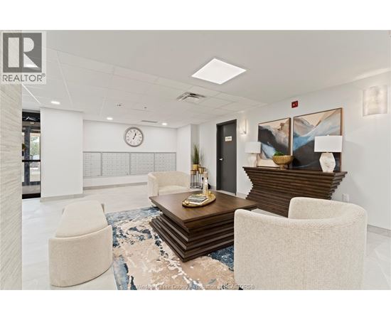 A modern office lobby with a wooden coffee table and two white chairs.