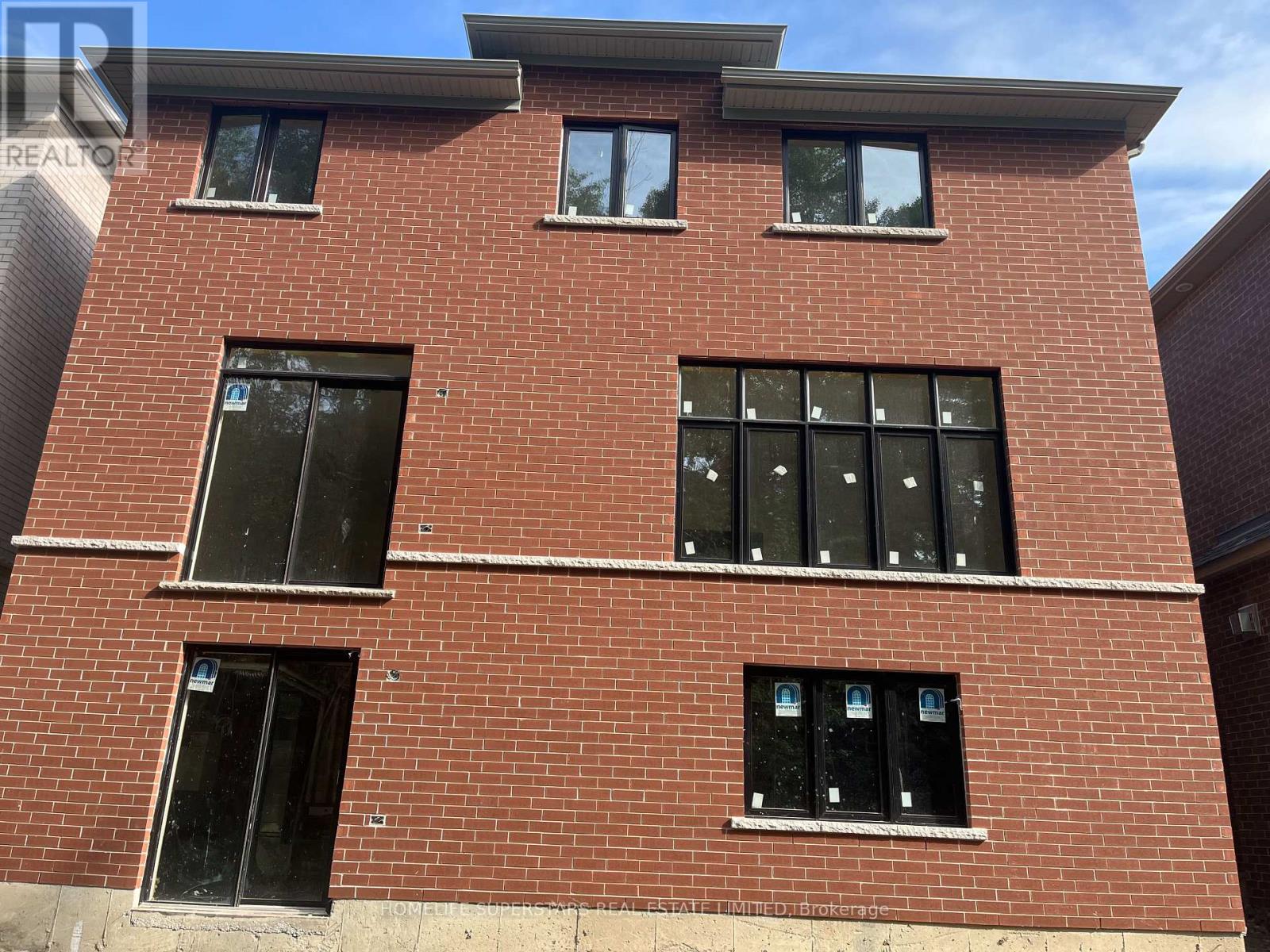 A red brick building with windows and a sign that says "REALTOR".