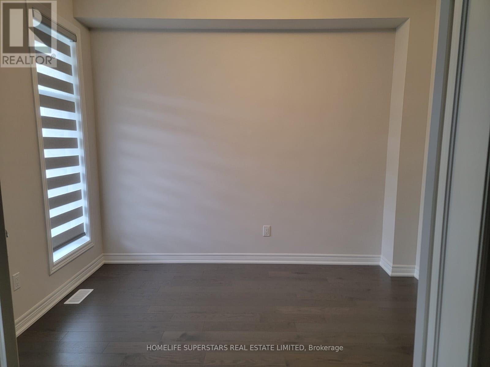 A room with a window and wooden flooring.